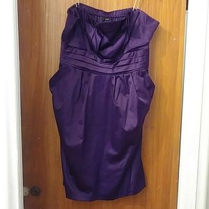 A purple gently worn strapless dress